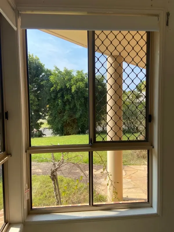 New aluminium-framed window with diamond security screen overlooking a tropical garden